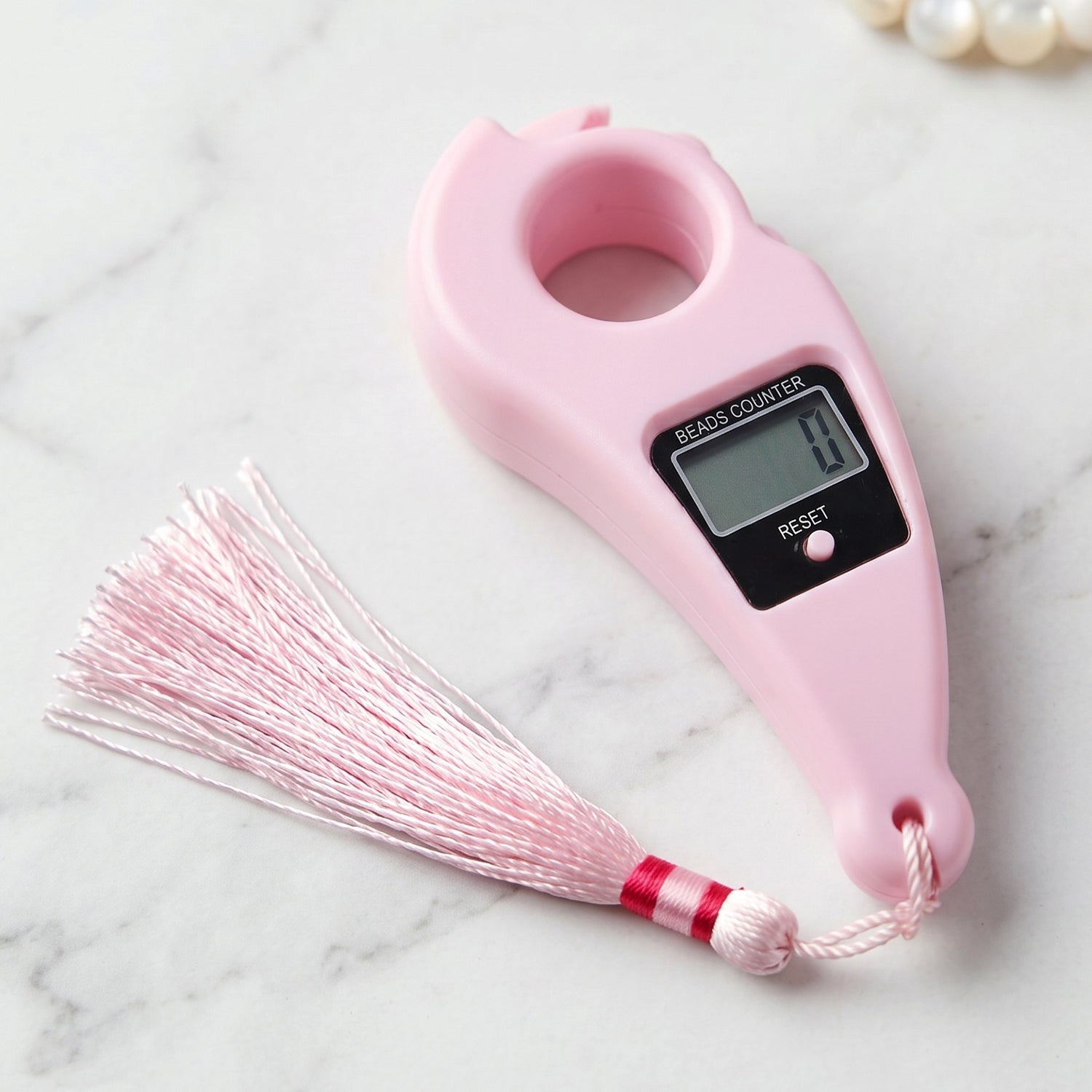 Close-up of pink digital mantra jaap counter with button and LCD screen pooja accessories